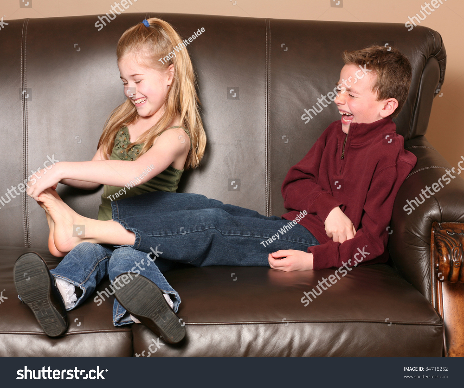 girl tickles her brothers feet