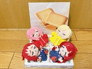 Peluches de Kusuri, Yaku, Hakari y Karane en una caja de galletas.