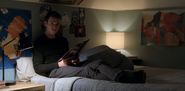 Justin reading comics on Clay's bed