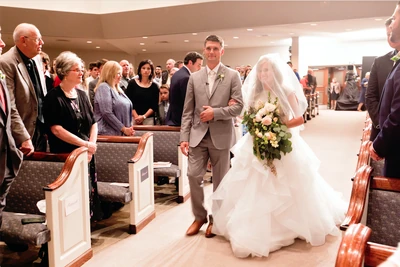 Kendra walks down the aisle with her father.