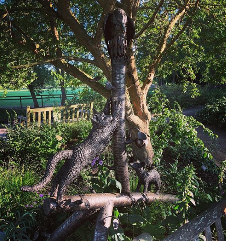 Sculpture featuring Pantalaimon and Kirjava was unveiled behind bench in Oxford botanical park.