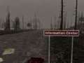 Das Hinweisschild mit dem Informationszentrum (Verbrannter Wald) im Hintergrund