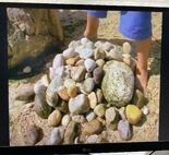 Some kids looking at these rocks at the beach.