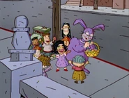 A man dressed as an Easter Bunny handing out candy to the kids.