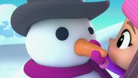 102a - Girl puts a carrot nose on a snowman