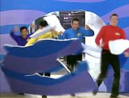 The Wiggles crashing through the wall in their flashback