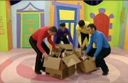 The Wiggles holding boxes of hats