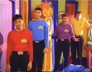 The Wiggles in mixed up shirts.