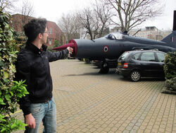 An Indian Air Force  in a parking lot with a Bandai Namco employee