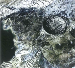 High-altitude image of the St. Ark Crater. The remnants of St. Ark Air Base's runway can be seen on the lower left edge of the crater.