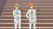 Hinata and Mitsuki dressed up in uniforms by the microphones