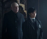 Uncle Fester standing next to Wednesday Addams