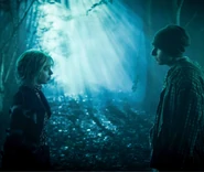 Enid Sinclair and Ajax Petropolus standing in the woods