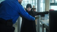 Lewis Cade using a medal detector on Wednesday Addams at the airport