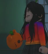 A player holding the Pumpkin Kitty Plushie.