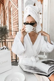 Clean girl sipping coffee with all-white accessories[9]