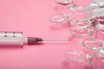 Syringe-needle-ampoules-pink-background-144256608