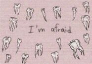 An illustration of multiple loose teeth surrounding written text, reading "I'm afraid".