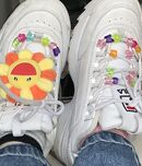 White shoes decorated with pony beads and a Takashi Murakami flower.
