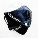 A black mask with two chains and a blue eyeball in the middle.