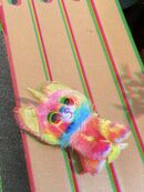 A glitchy edit of a photograph of a "Yips the Unicorn Chihuahua" Ty plush lying on the floor, crying with blood on their body.