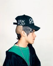 An example of the patilludo hairstyle complemented by a baseball cap.