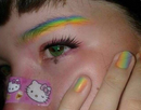 A person with rainbow-themed makeup and a Hello Kitty bandage.