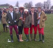 Barbour jackets, red trousers, and wellies. (The fur hats are NOT Sloane)