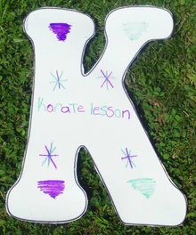 "K" for "Karate."Karate lessons is a good place to learn how to kick too.