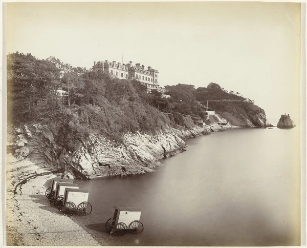 Beacon Cove circa 1890s. The bathing machines are typical of what Agatha Christie would have used. In the centre is the Imperial Hotel. End House is unfortunately covered by trees. Note to the right a small structure by the sea. This is at the end of a descent leading to the sea from the Coastal Path above. Perhaps this is the place mentioned by Nick Buckley: "There’s a scrambly cliff path down to the sea. I go down that way to bathe. There’s a rock you can dive off. A boulder got dislodged somehow and came roaring down just missing me."