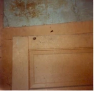 A second image of the door with a bullet hole.