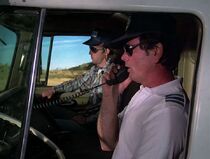 The truck driver in white has a line or two speaking to Stoner on the radio and he is played by Gary McLarty. The other one is not credited.