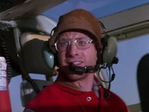 Director-Santinis millions.jpg (45 KB) Film director in Dominic's helicopter. Here he is scared to death because a small charge has just blown the control rod off the tail rotor.