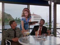 Dani Douthette as the waitress. She tells Hawke and Aaron how much she dislikes the casino whose renovation has resulted in her losign her home. The structure can be seen in the background.