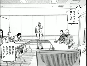 亜人管理委員会の会議室とみられる部屋。中央に戸崎優が立っている。左から2番目には岸祐二が座っている。