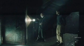 Warden James leading Harlan Simmons into the room.