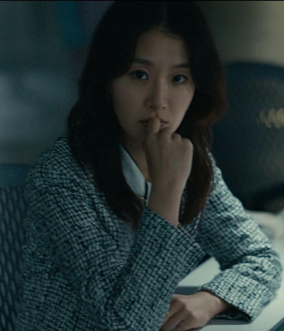 A close-up shot of Shion sitting thoughtfully with her hand near her face