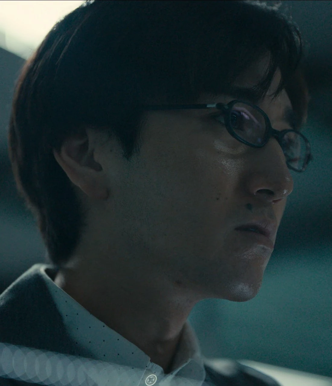 A close-up of Masato wearing glasses and looking to the side with a serious, focused expression
