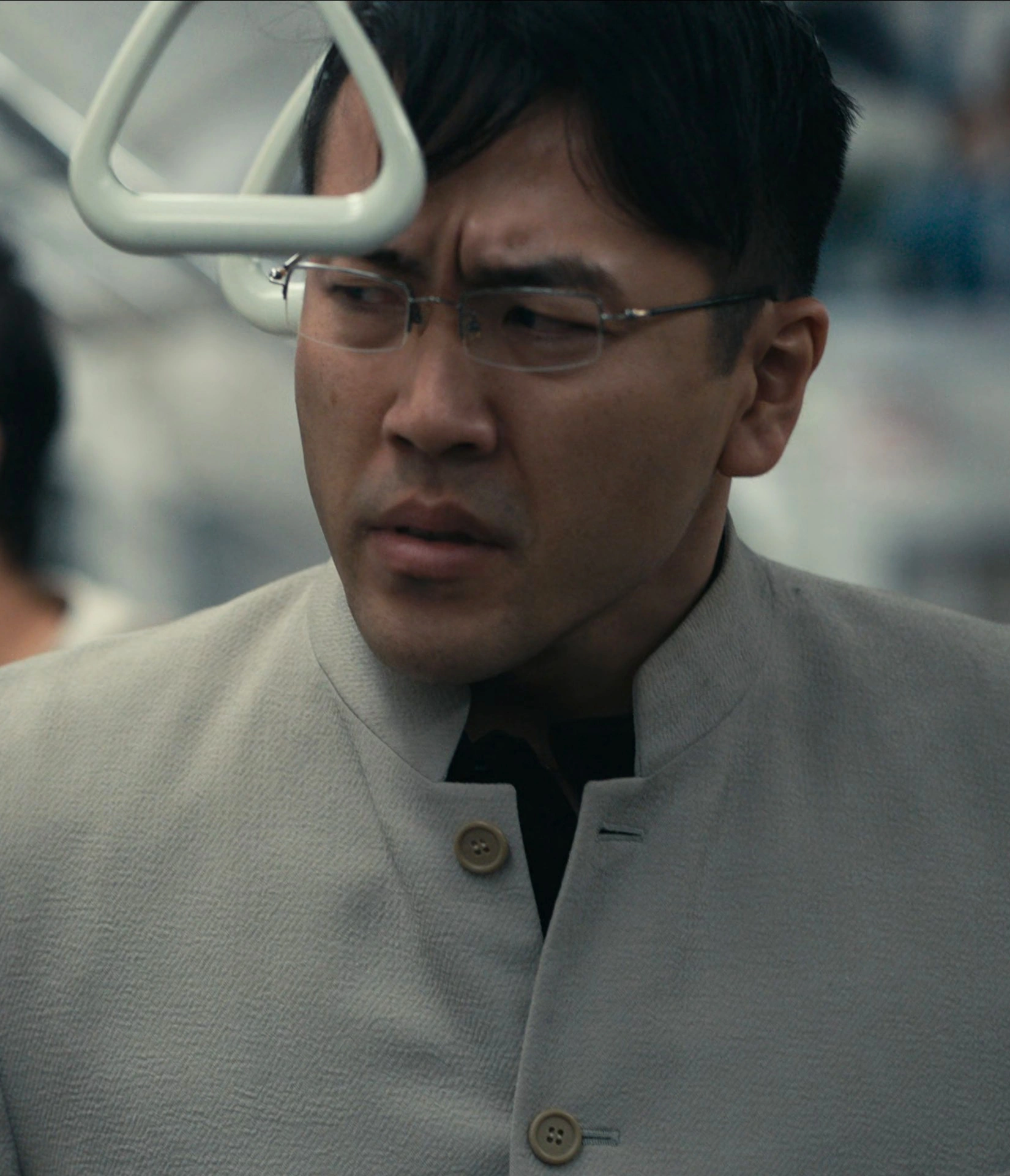 A screenshot of an unnamed male player in a white suit and glasses, looking confused