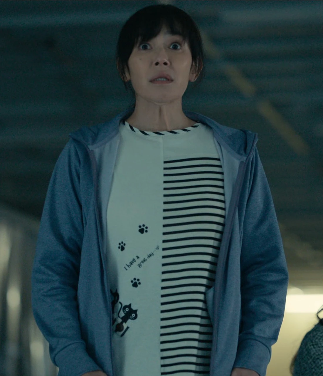 A close-up shot of Sachiko in a striped shirt with a shocked expression
