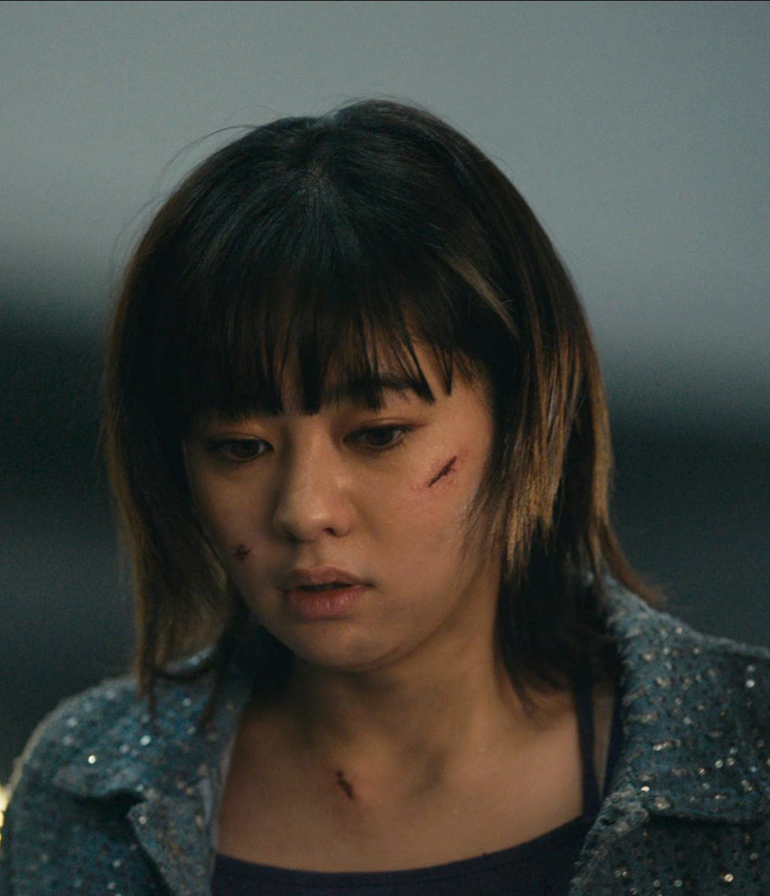 A close-up shot of Natsu in a shopping center, looking down in shock and disbelief