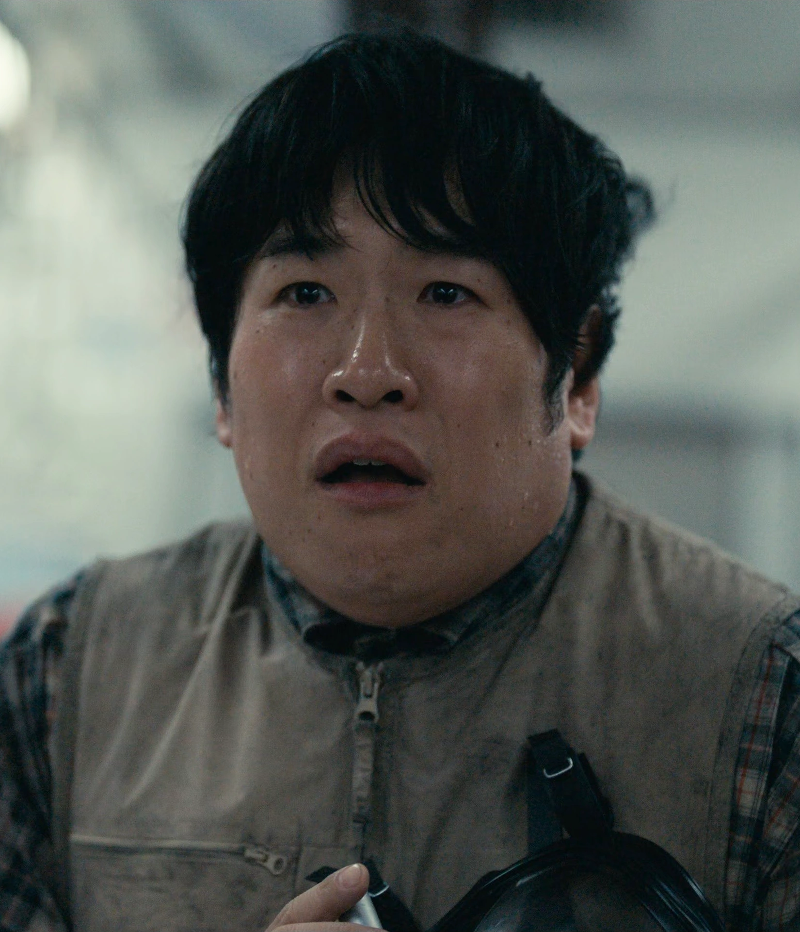A screenshot of Taro from Season 3, a man of a large build in a beige vest over a checkered shirt, looking terrified