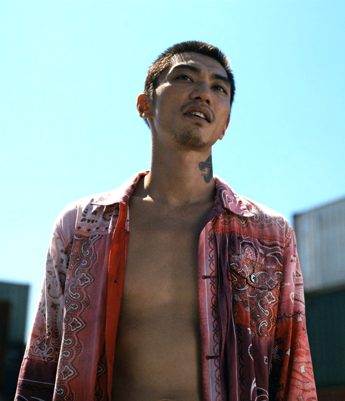 A screenshot of Goken from Season 2, a man wearing an unbuttoned pink shirt