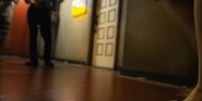 Camera angle from the bottom, it captures only a hallway, a wall of blue lasers, and Shibuki's shoe