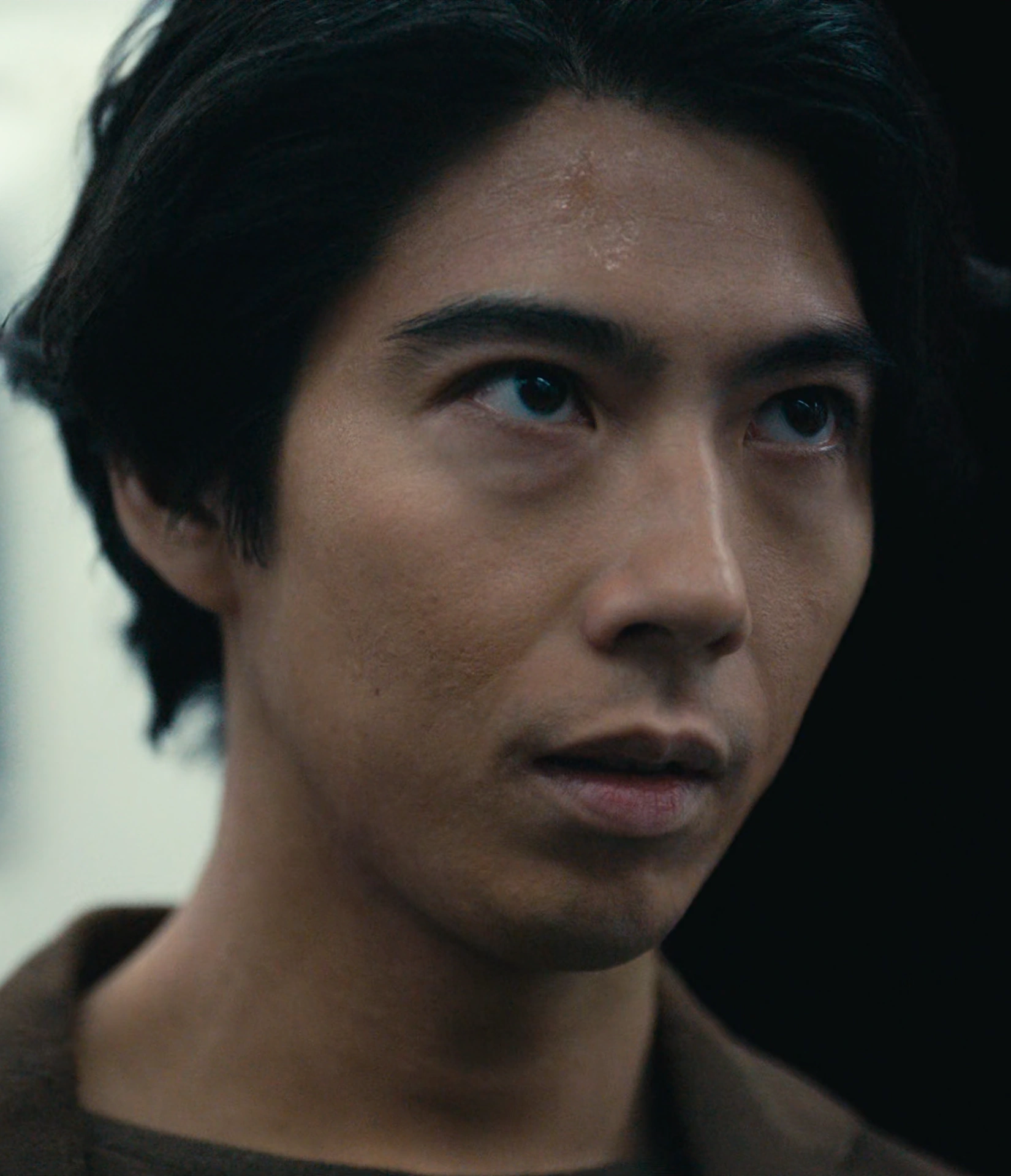 A screenshot of Ryuji Matsuyama from Season 3, a man with short curly hair in a suit, looking up with concern
