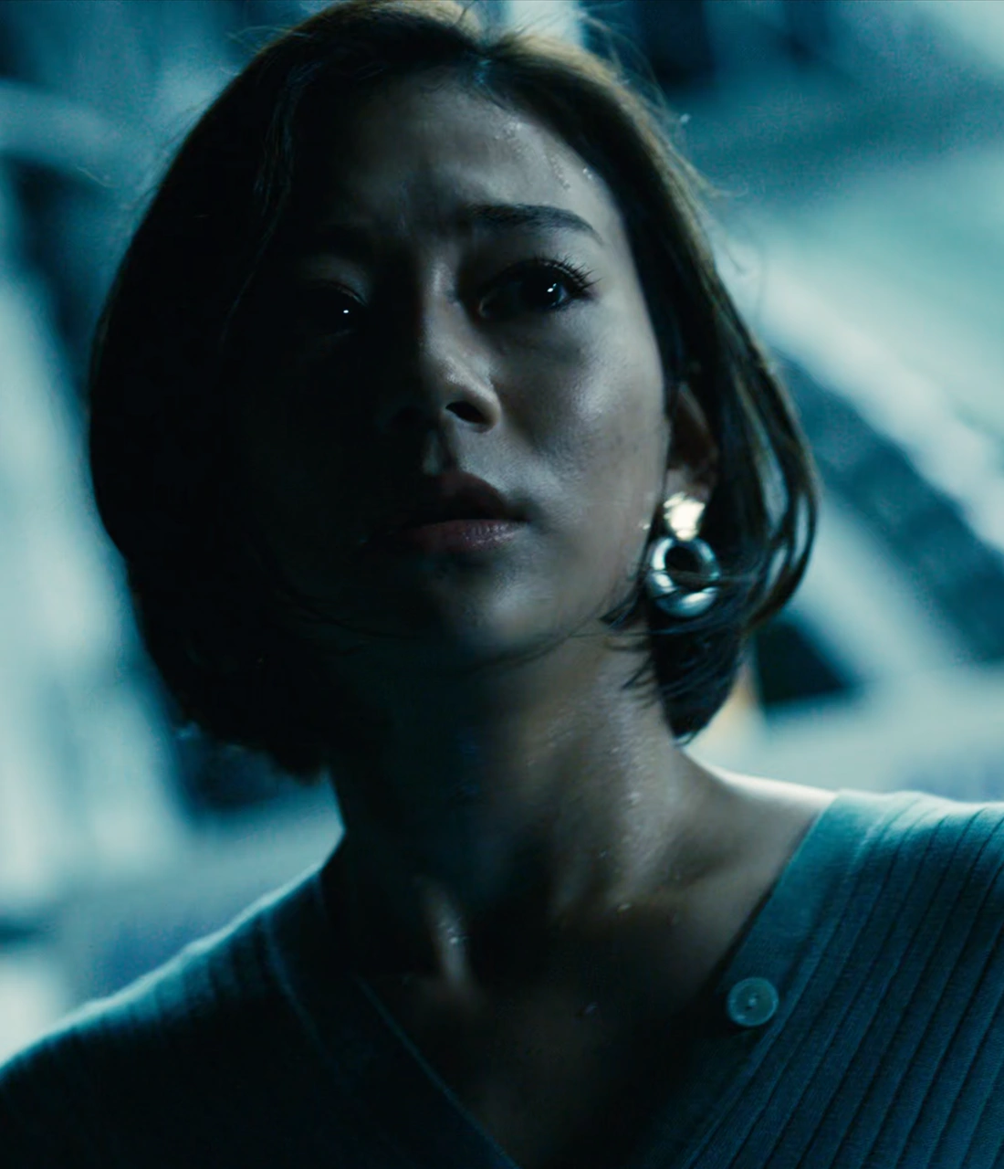 A close-up shot of Mizuki, a young woman with short dark hair, who is sweating and nervously looking aside