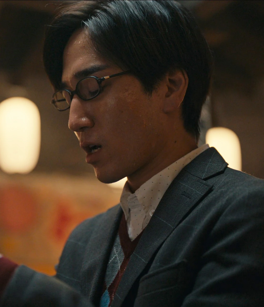 A close-up shot of Masato holding a fortune slip and reading it closely with sweat on his face