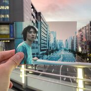 AIB Netfix BTS 03.jpg (121 KB) A photo of Arisu looking for people in Tokyo, the screenshot is held by someone's hand, and the person is standing in the same place where the scene was filmed