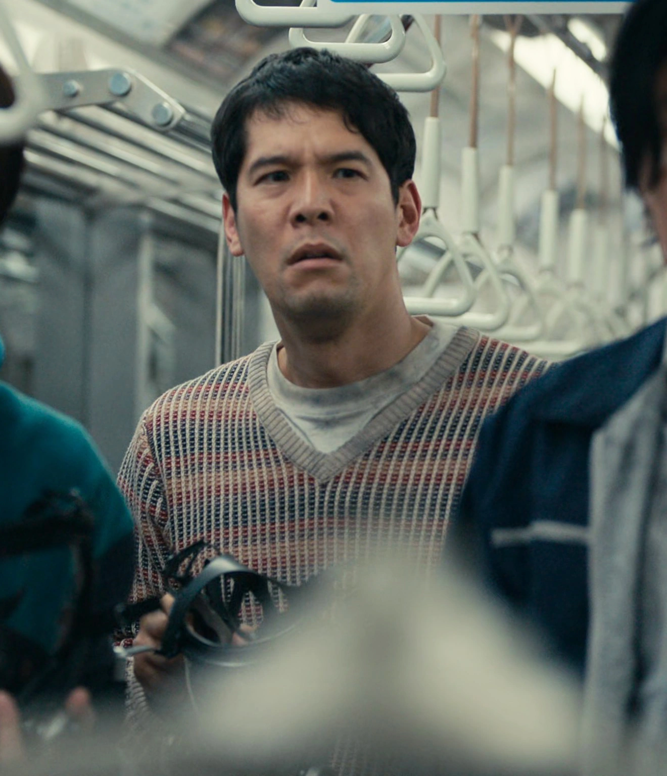 A screenshot of an unnamed male player in a knitted V-neck sweater with thin stripes in different muted colors