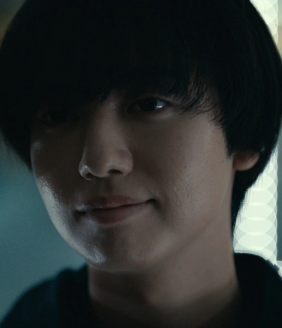 A close-up of Mano with a faint, confident smile on his face